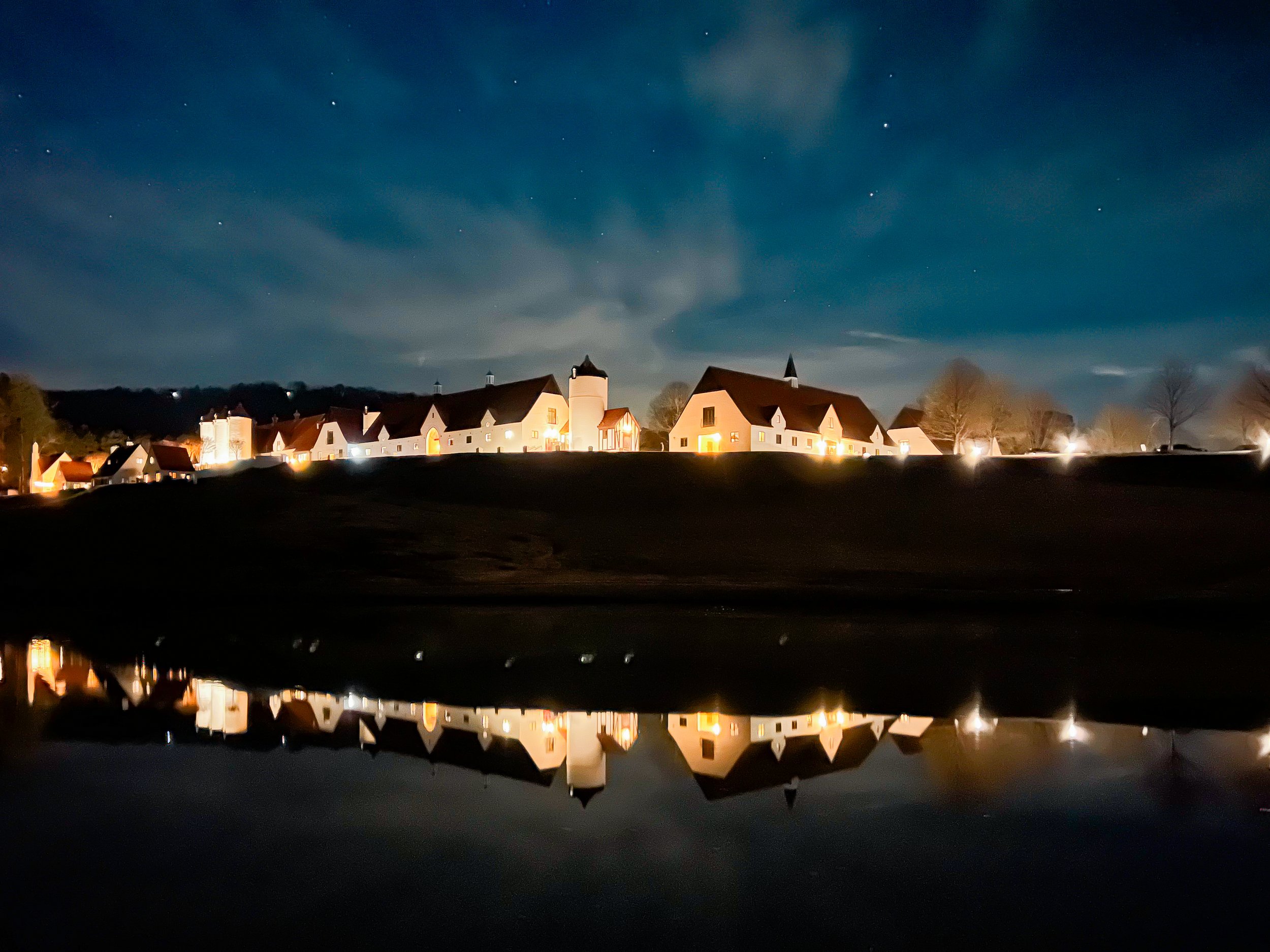 Lit-up homes reflected on a lake at night