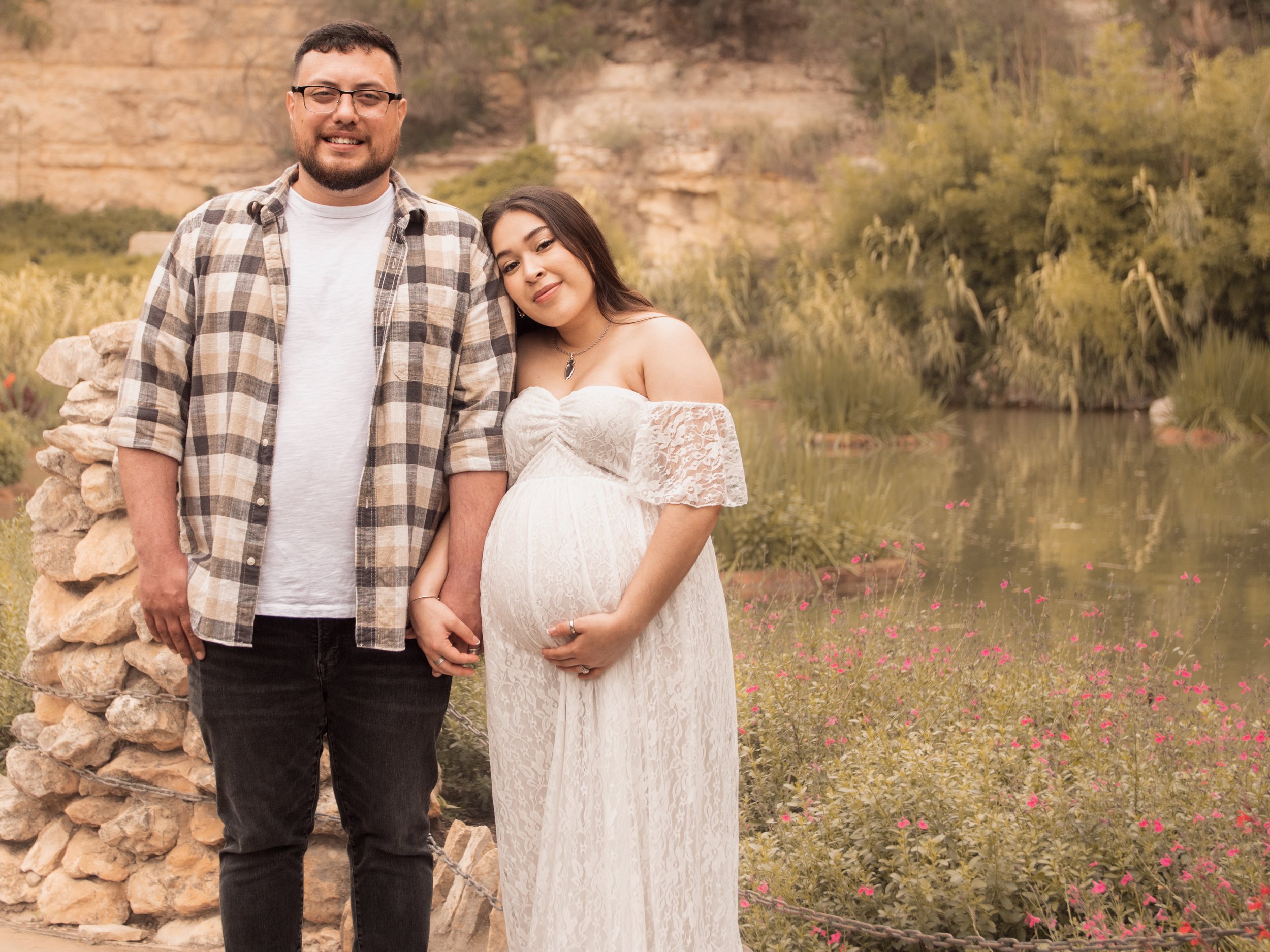Expecting couple by a stone wall