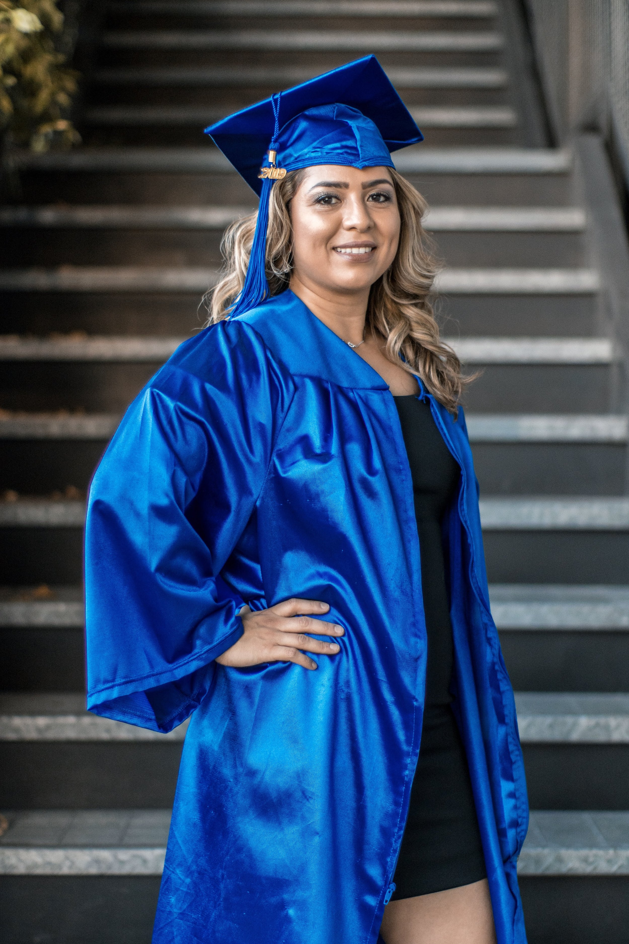 Graduate in a blue gown on stairs